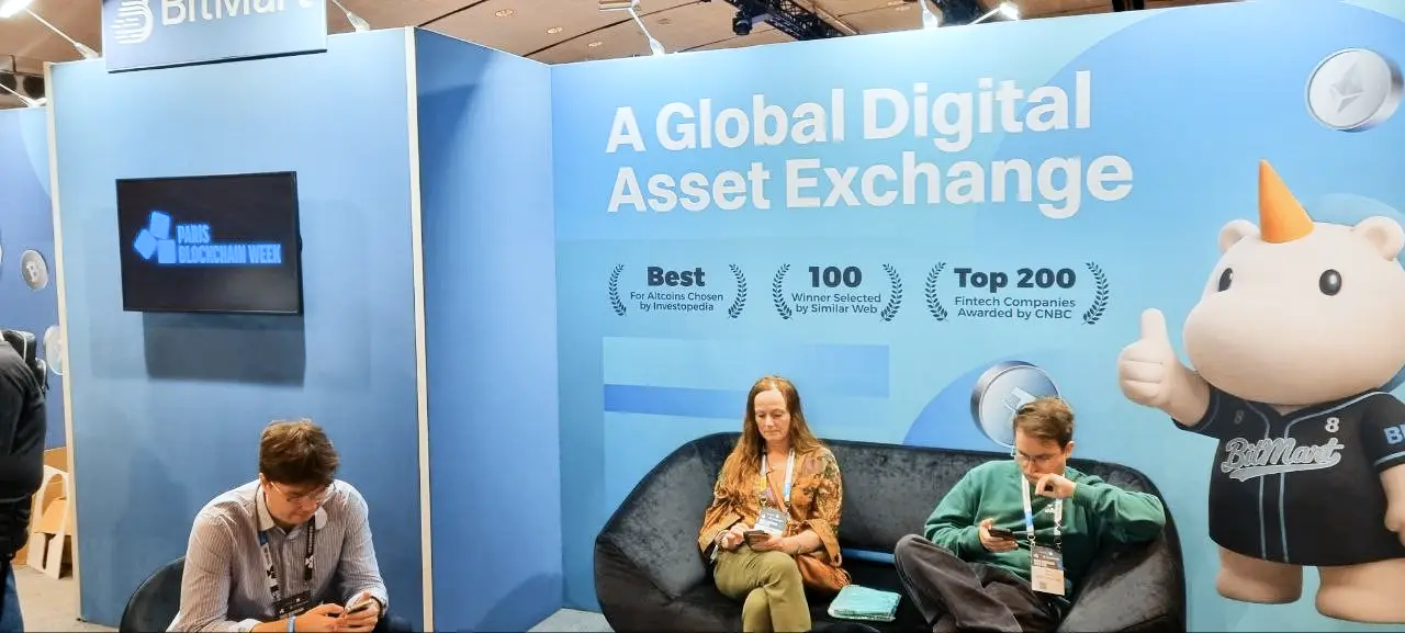 BitMart exchange booth at Paris Blockchain Week featuring award displays and a mascot.