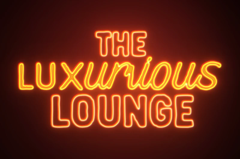 A glowing orange and yellow neon sign displaying the text "THE LUXURIOUS LOUNGE" against a dark, elegant background
